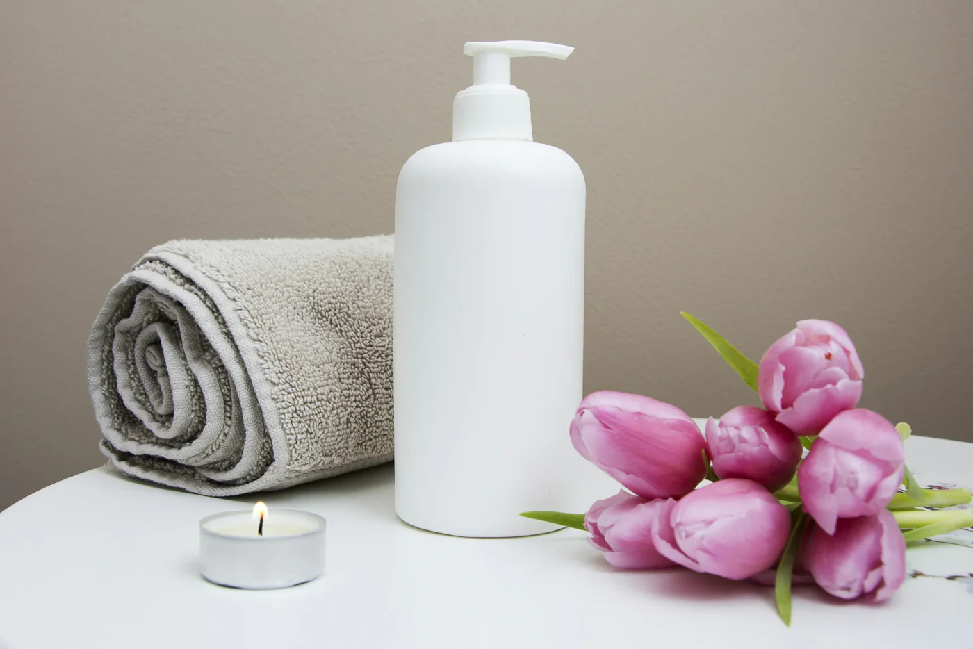 Handtuch, Kerze und Blüten